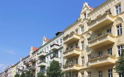 Investieren gelbes Wohnungshaus mit Balkonen