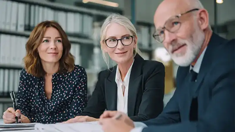 Drei Personen im Gespräch am Konferenztisch