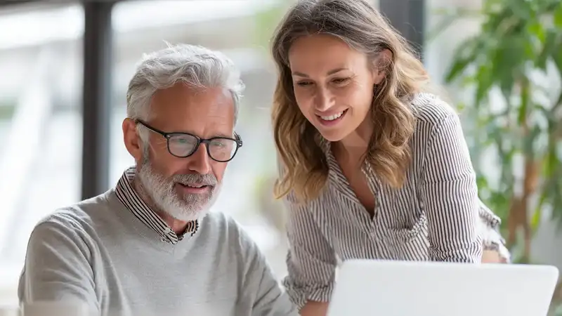 Zwei Personen bei Immobilienberatung am Laptop