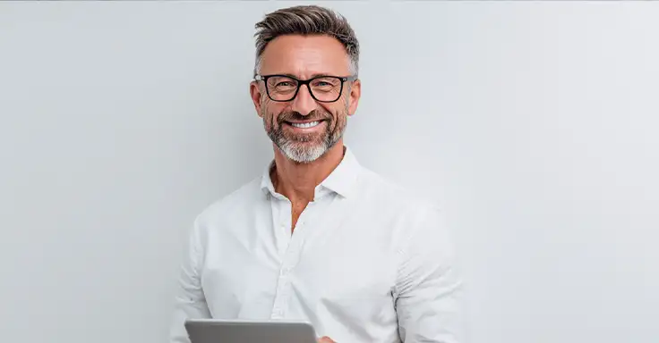 Mann mit Brille und Tablet lächelt in die Kamera